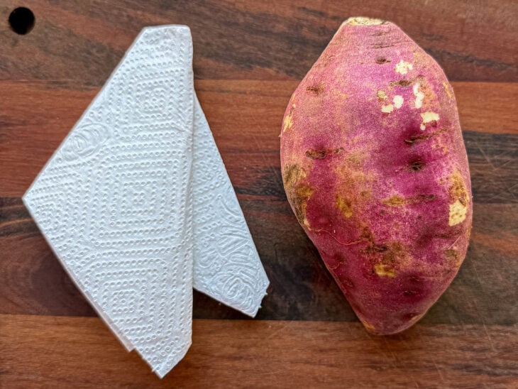 Batata-doce e folha de papel-toalha organizadas sobre a bancada para iniciar o preparo.