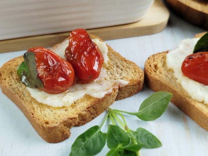 Tomate confit com queijo servido.