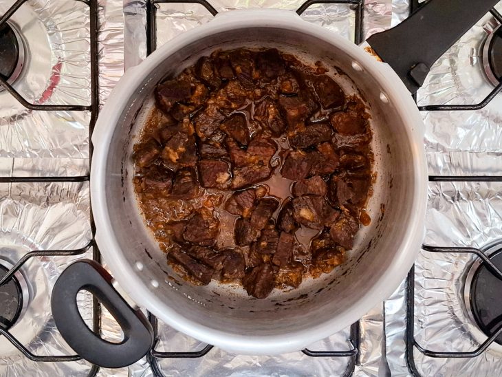 carne na panela de pressão com água para cozimento.