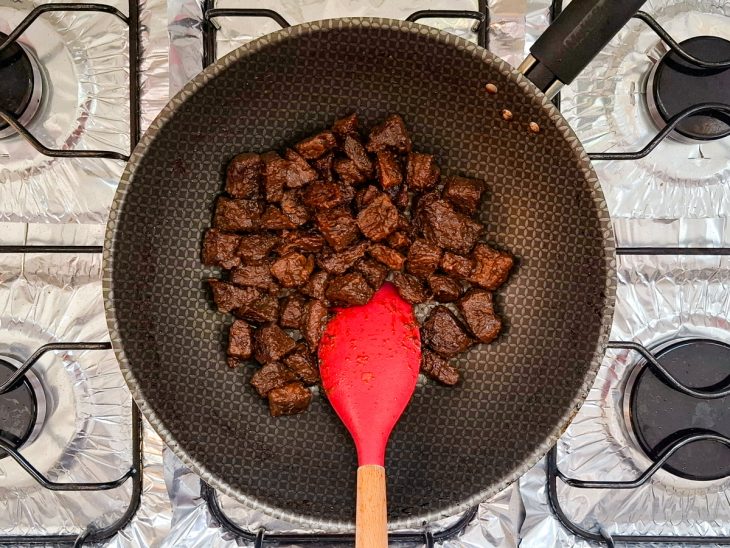 carne de volta na frigideira co óleo para fritar por completo.