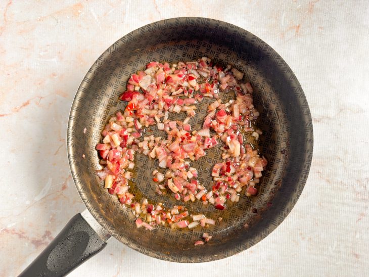 Cebola refogada na manteiga na frigideira.