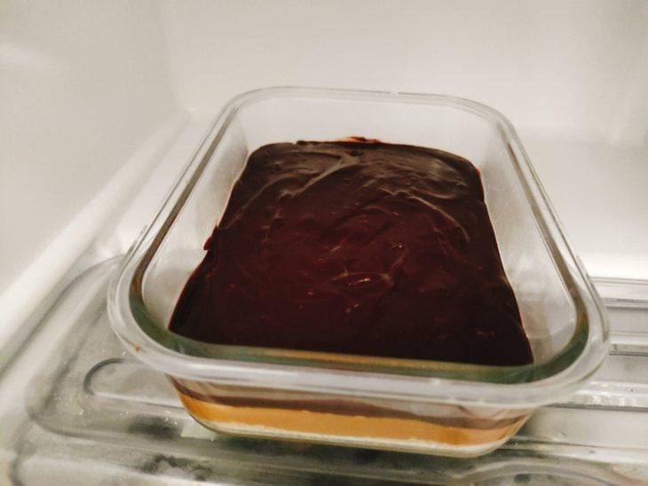 Ganache despejada sobre a camada de doce de leite.