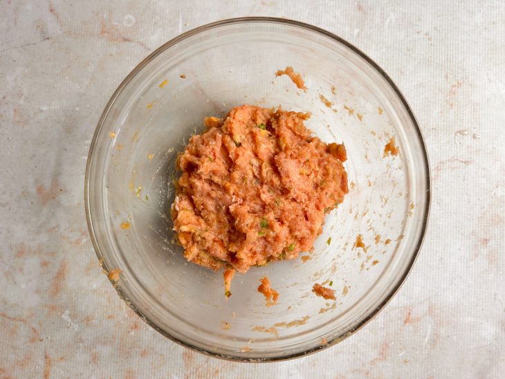 Carne de frango moída e temperos misturados.