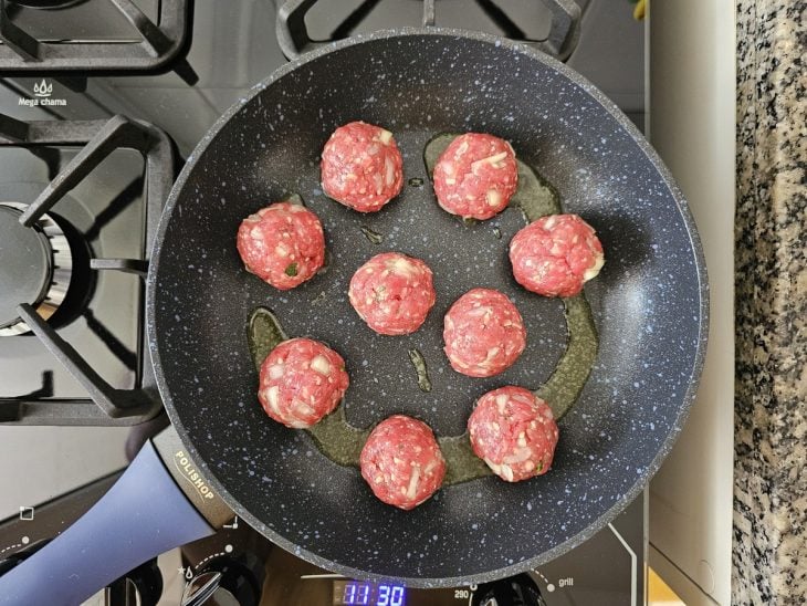 Uma frigideira contendo almôndegas sendo fritas.