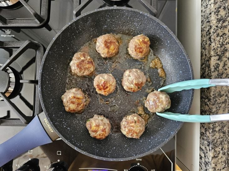 Uma frigideira contendo almôndegas sendo fritas.