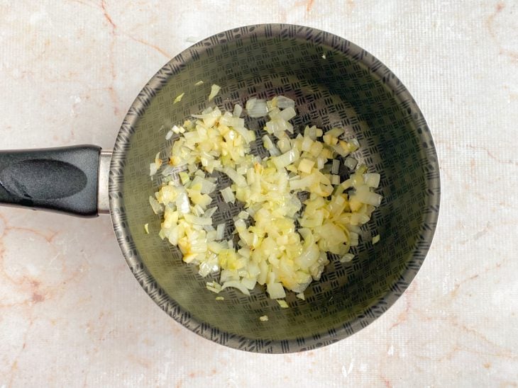 Alho e cebola em uma panela com azeite para refogar.