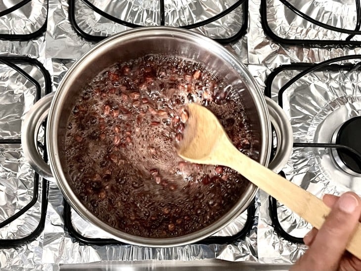 Uma panela com amendoim e calda de açúcar brobulhando.