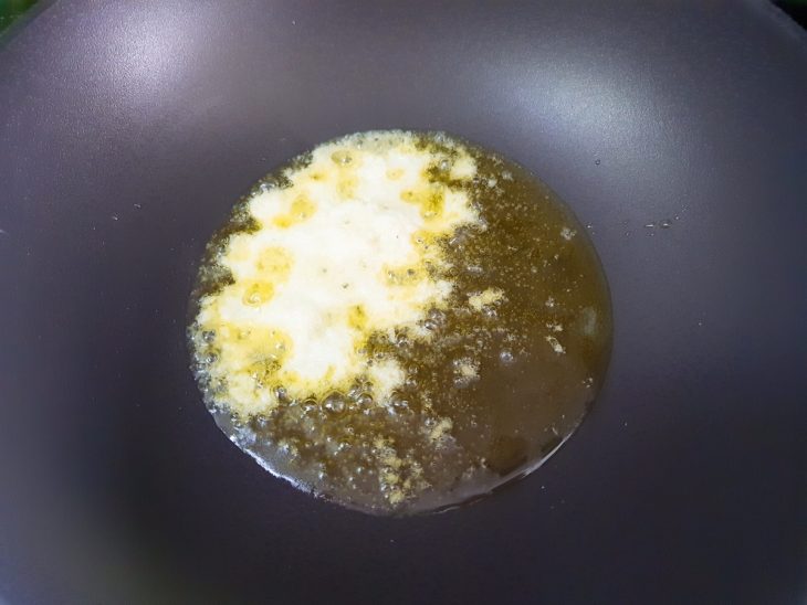 Uma panela com azeite, cebola e alho.