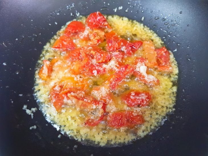 Uma panela com azeite, cebola, alho, pimenta-dedo-de-moça e tomate.
