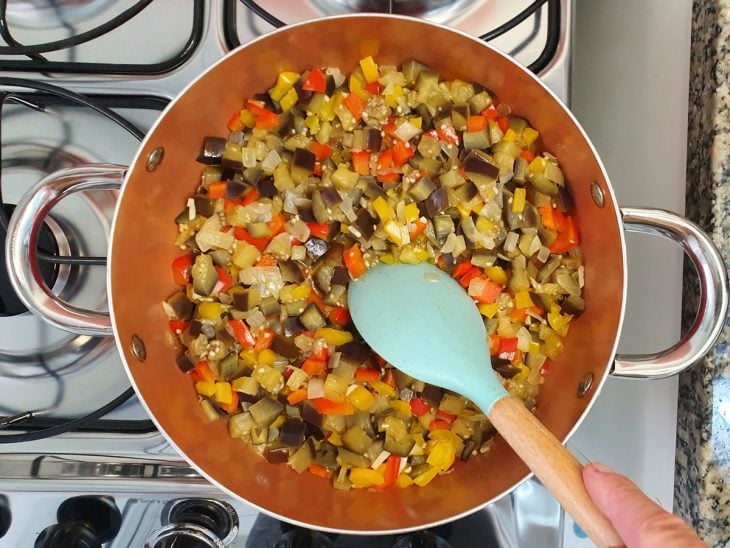 Berinjela com outros ingredientes na panela refogados.