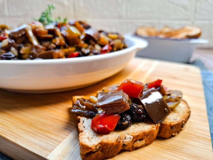 Antepasto pronto ao fundo, torrada servida com o antepasto em primeiro plano.