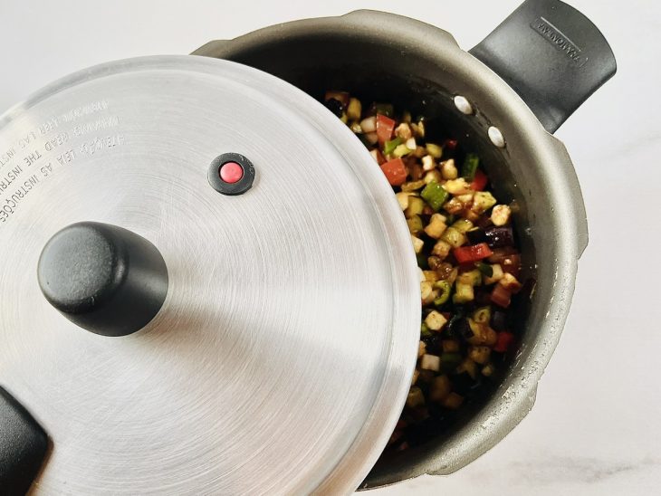 Panela de pressão com todos os ingredientes, sendo fechada.
