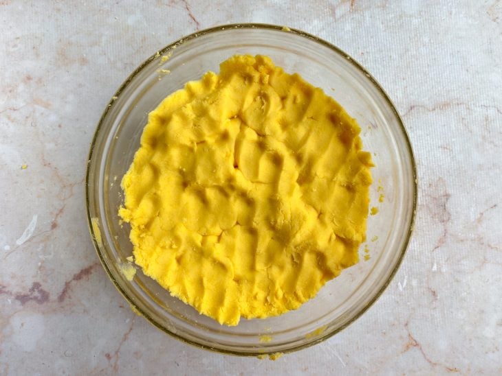 Farinha incorporada com água na tigela de vidro redonda.