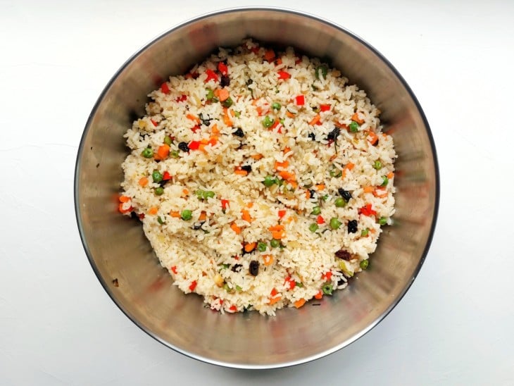 Todos os ingredientes do arroz misturados em uma vasilha.