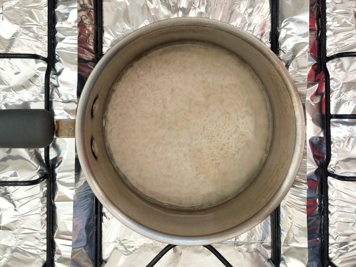 Uma panela contendo arroz e água.