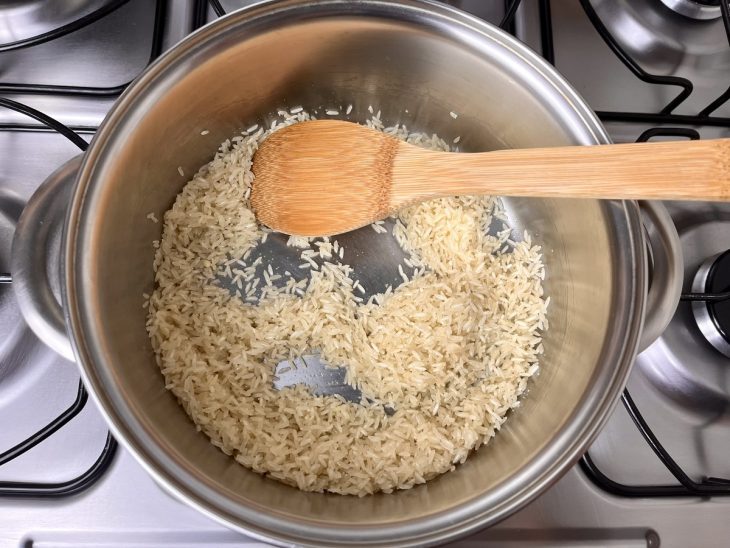 Panela com arroz cru sendo refogado.