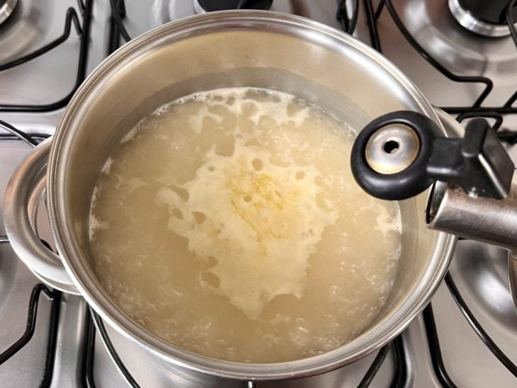 Panela com arroz coberto por água.