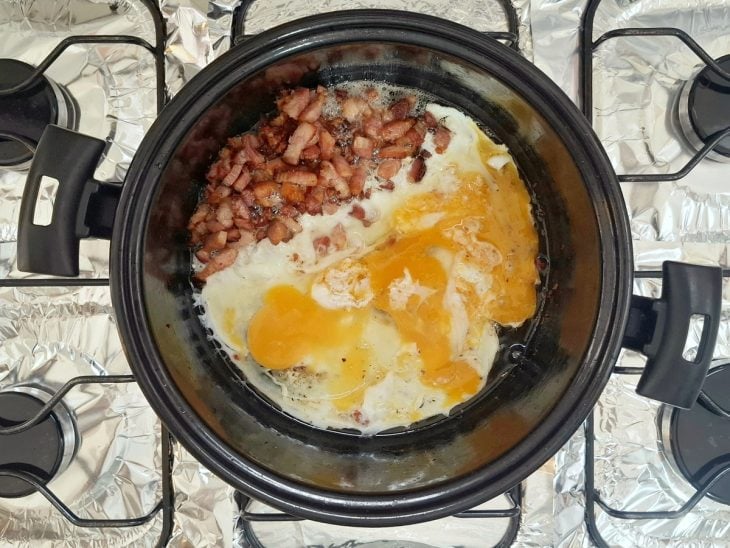 Ovos adicionados a panela com bacon.