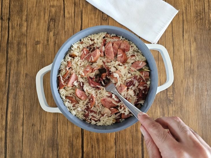 Panela com arroz e outros ingredientes cozidos e sem a água.