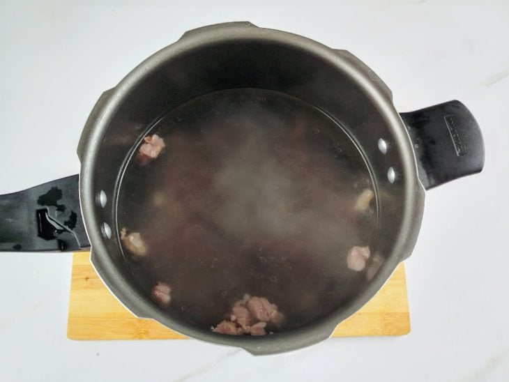 Uma panela com carne-seca e água.