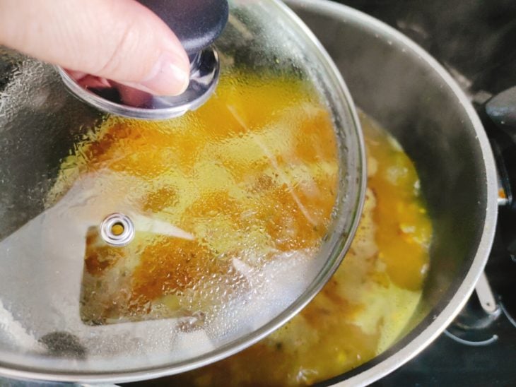 Panela com arroz sendo tampada.