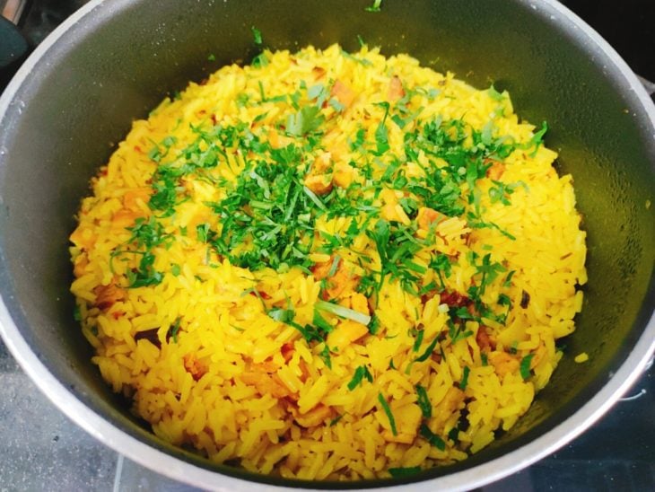 Uma panela contendo arroz com açafrão e bacon.