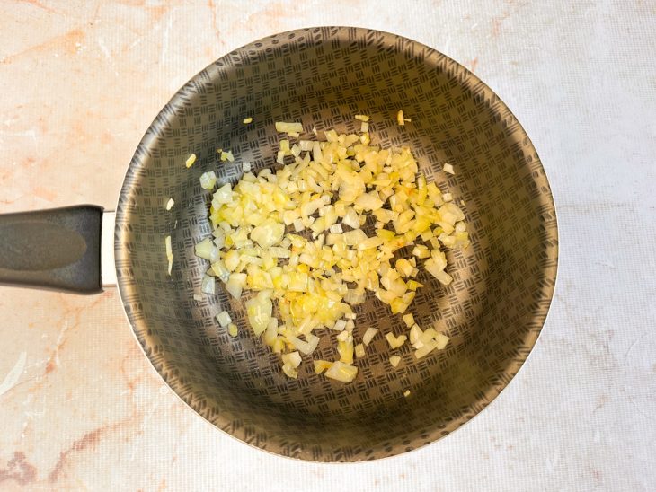 Alho e cebola refogados numa panela.