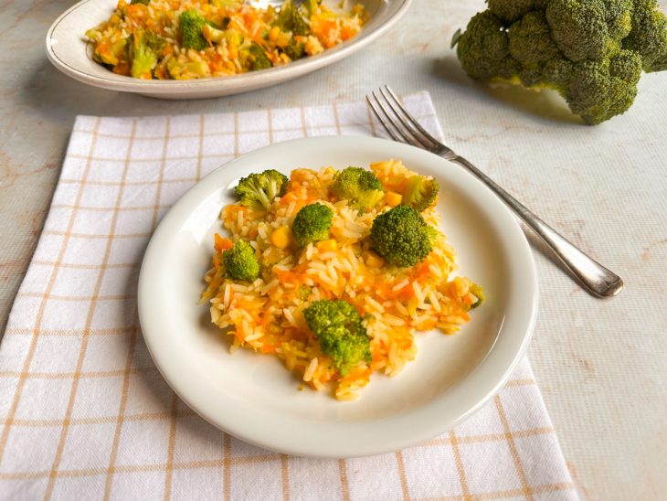 Arroz com brócolis e cenoura servido num prato individual.