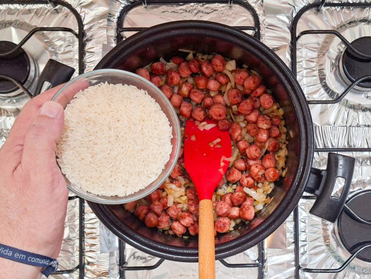 Arroz sendo adicionado na panela.