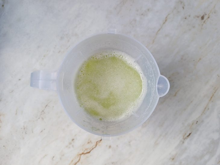 Talos de brócolis sendo batidos no liquidificador com água.