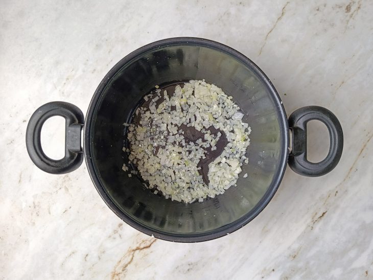 Alho e cebola refogados em panela média com óleo.