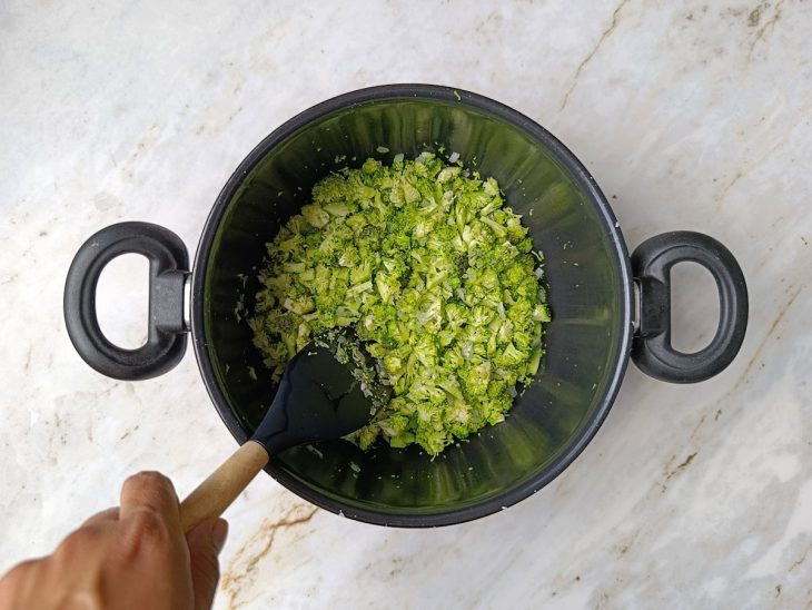 Brócolis picado sendo refogado junto ao alho e à cebola.