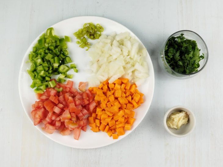 Legumes, temperos e ervas já picados e separados para o preparo.