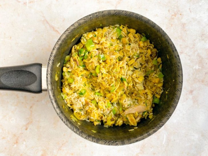 Milho e arroz cru adicionados à panela.