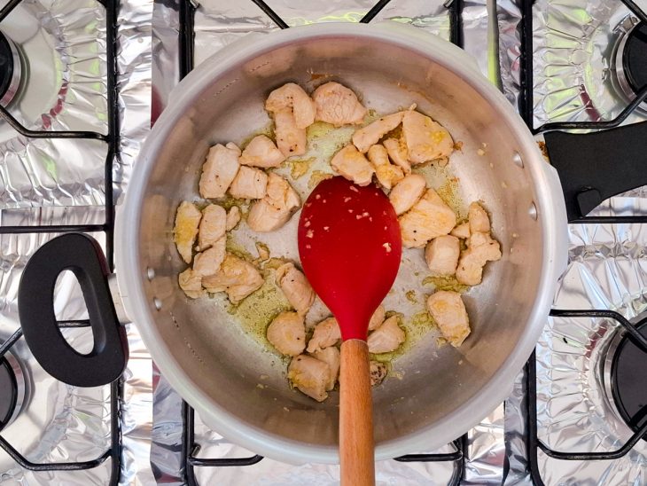Panela com alho e cubos de frango.