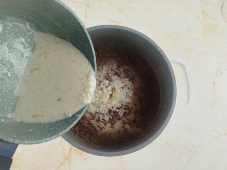 Especiarias sendo retiradas e o leite quente sendo despejado sobre o arroz.