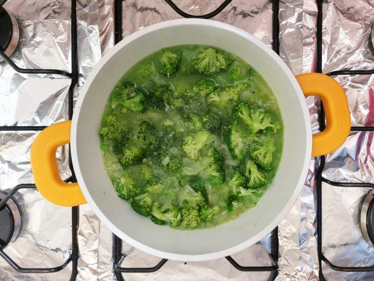 Uma panela com arroz, brócolis e caldo de folha de brócolis.