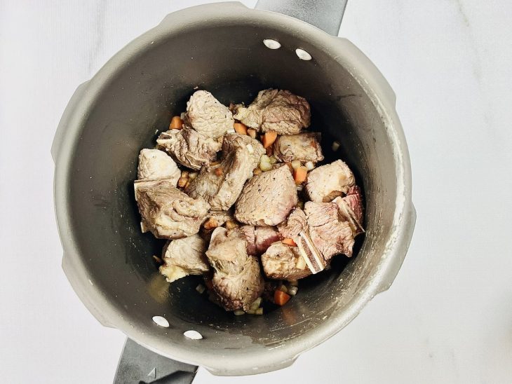 Cebola e cenoura adicionadas a panela.