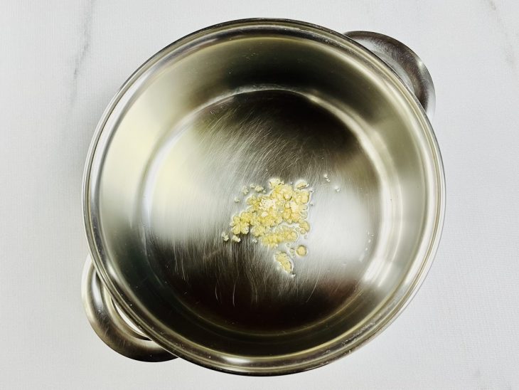 Manteiga de garrafa e alho em uma panela.