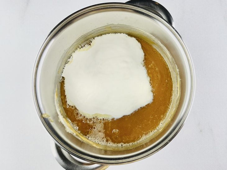 Creme de leite sendo misturado ao caramelo.