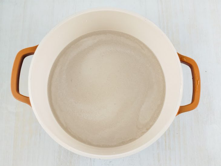 Arroz cru sendo cozido na panela.