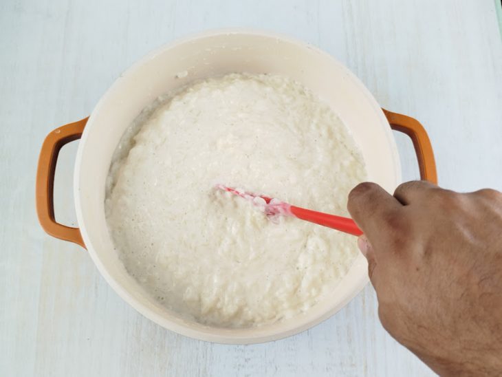 Arroz de leite simples sendo mexido com uma colher.