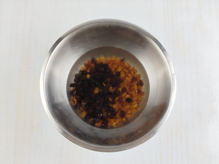 Na tigela, as uvas passas hidratando no vinho.