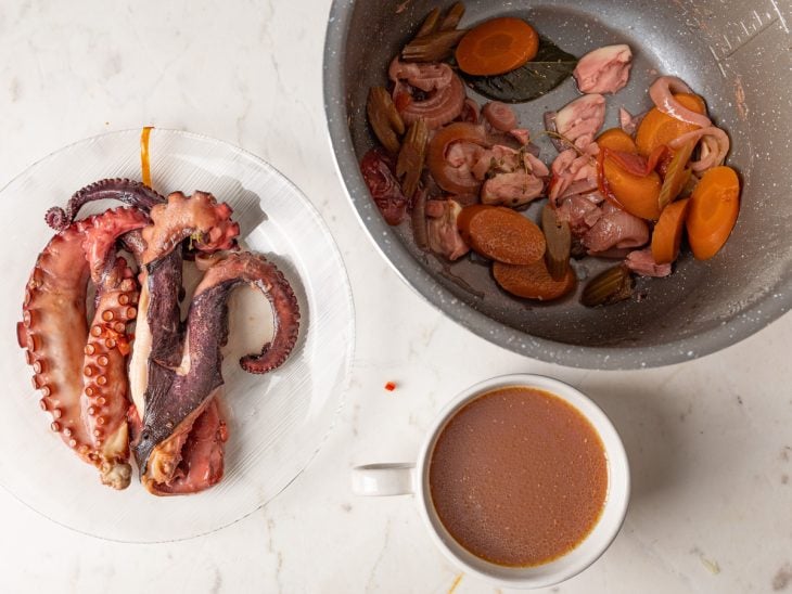 Polvo retirado da panela e caldo reservado em uma tigela.
