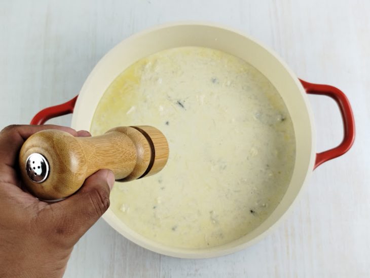 Na panela, sal e pimenta sendo adicionados.