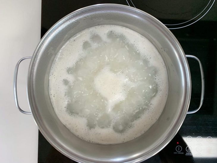 Panela com arroz e água fervendo.