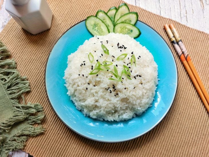 Prato com arroz japonês com alguns pepinos e gergelim enfeitando.