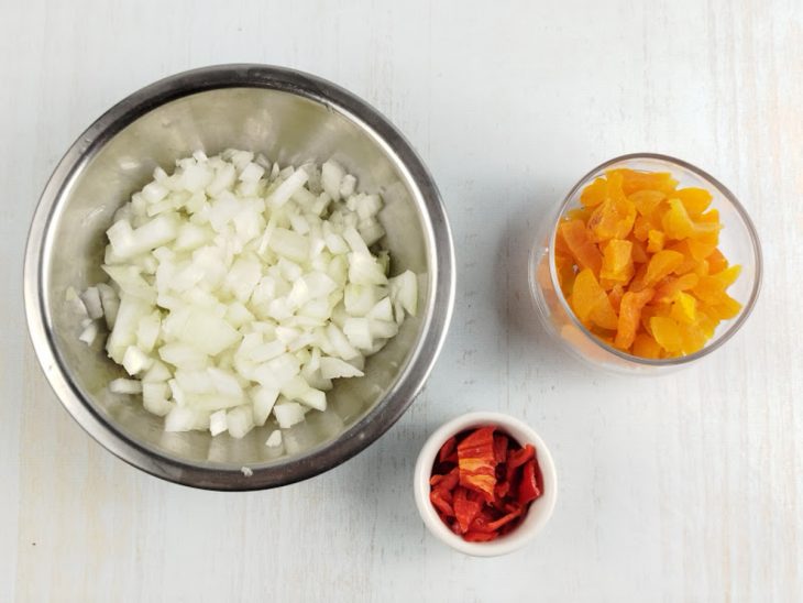 Cebola, pimenta e damascos cortados e reservados.