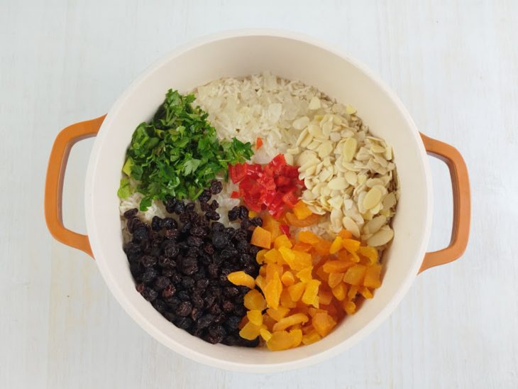 Na panela, a uva passa, os damascos, a pimenta, a salsinha e as amêndoas adicionadas.