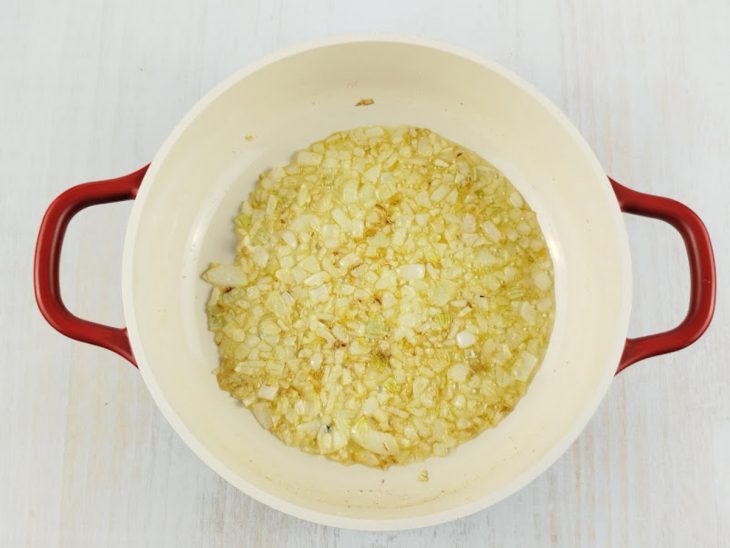 Cebola e alho dourados na panela.